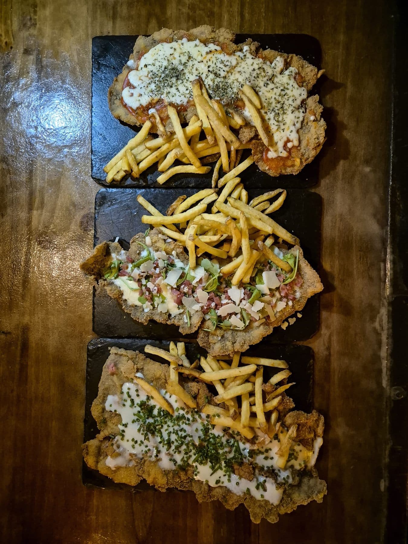 Tres milanesas sobre pizarras